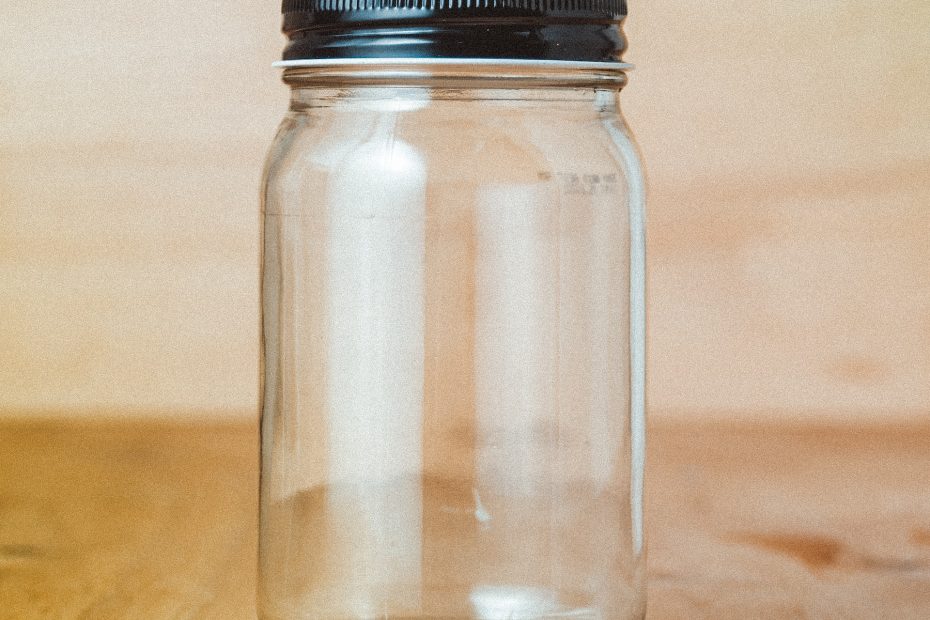 Empty mason jar in front of a wood wall